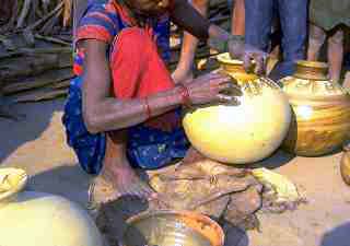 Tharu woman fingerpaints water jar 